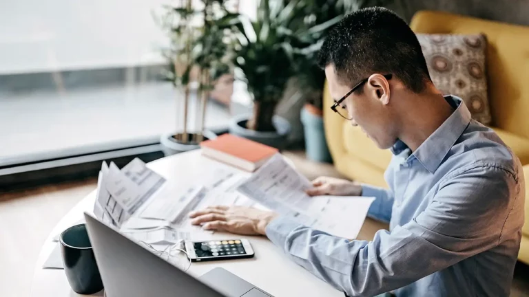 Japanese man calculating financial bills at home