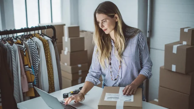 woman fulfilling order with box and laptop