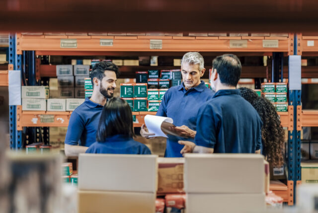 Supervisor discussing delivery schedules with warehouse staff