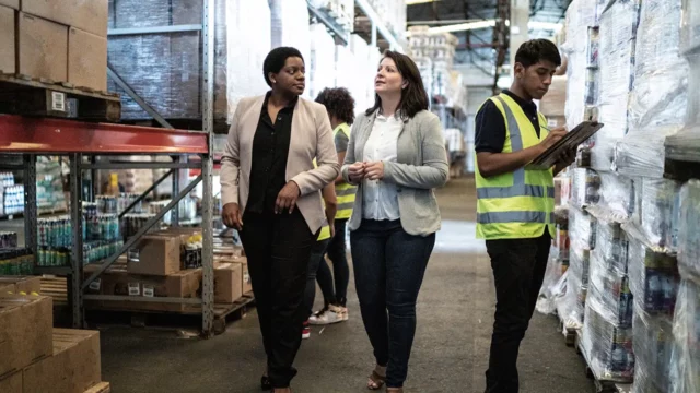 procurement manager talking with suppliers in warehouse