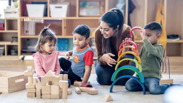 daycare manager with kids on playmat